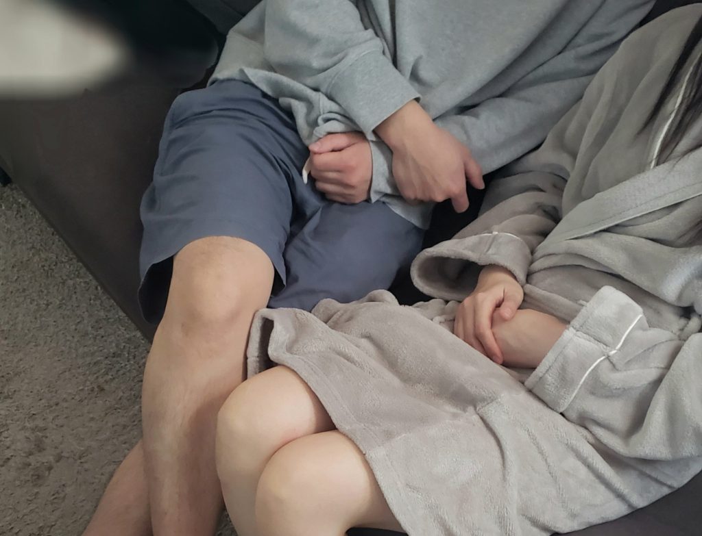 ソファに座る寝取りの伝道師クロエと寝取られ彼女の足元。自宅での３P寝取りは実現するのか？