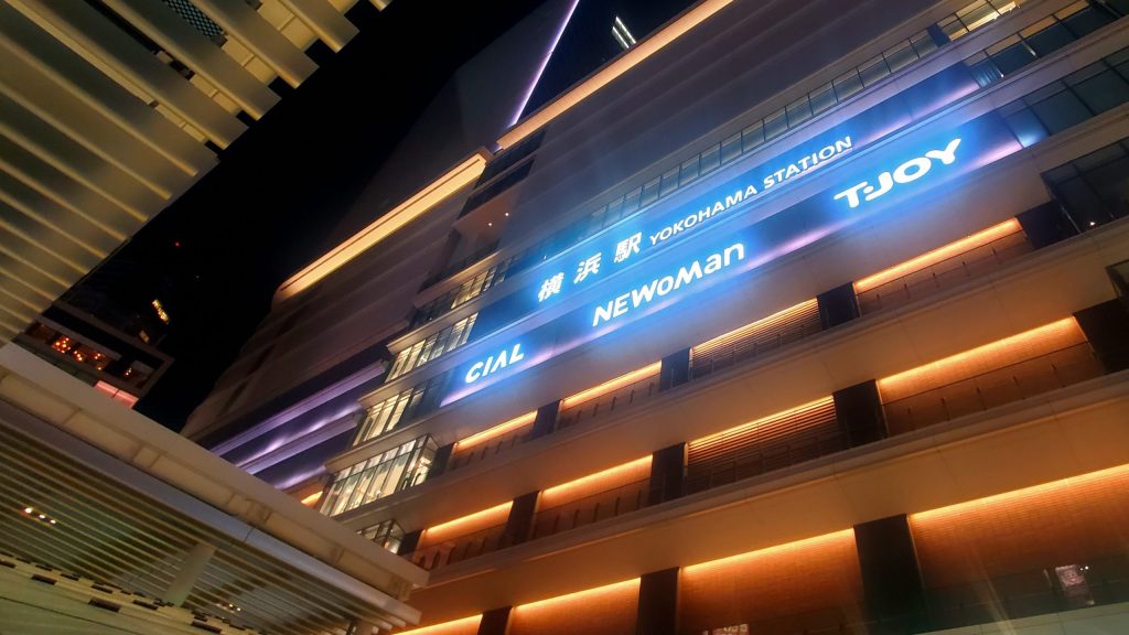 横浜駅前の夜景。寝取りの伝道師クロエが“バリキャリ人妻”との背徳的な密会を果たす舞台、NEWoMan横浜が幻想的に輝く。NTRの火蓋が切って落とされる、運命の夜が始まる場所。