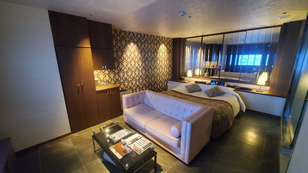 京都ラブホテル『HOTEL MYTH CLUB』の客室—ソファとベッド、鏡張りの内装｜寝取りの伝道師クロエのねとりっぷ外伝〈京都編〉、性癖マッチンで出会った単独女性との名器プレイ体験の舞台