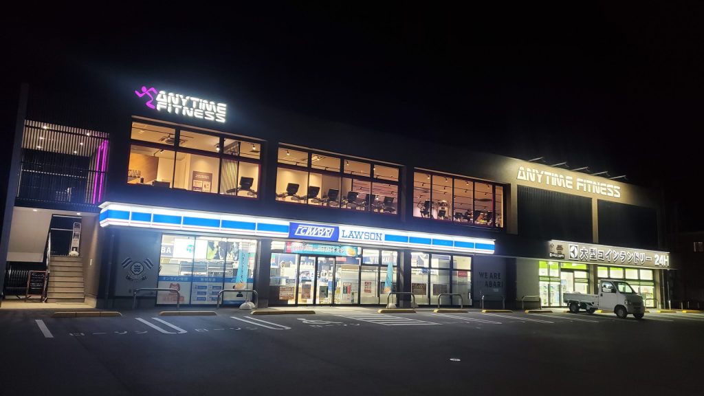 愛媛県今治市の夜に立ち寄ったエニタイムフィットネス外観画像。今治駅到着後、ラブホテルでの寝取らせNTR体験前にトレーニングで身体を整える「ねとりっぷ愛媛編」のルーティンシーン。
